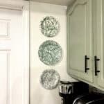 three green and white circular plates on a wall in a kitchen