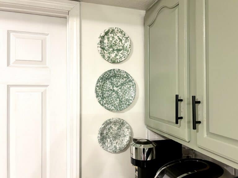 three green and white circular plates on a wall in a kitchen